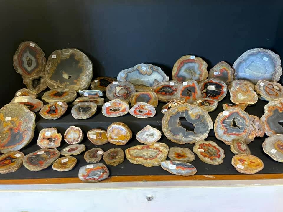 A large assortment of agate nodules and polished faces arranged for viewing and comparison.