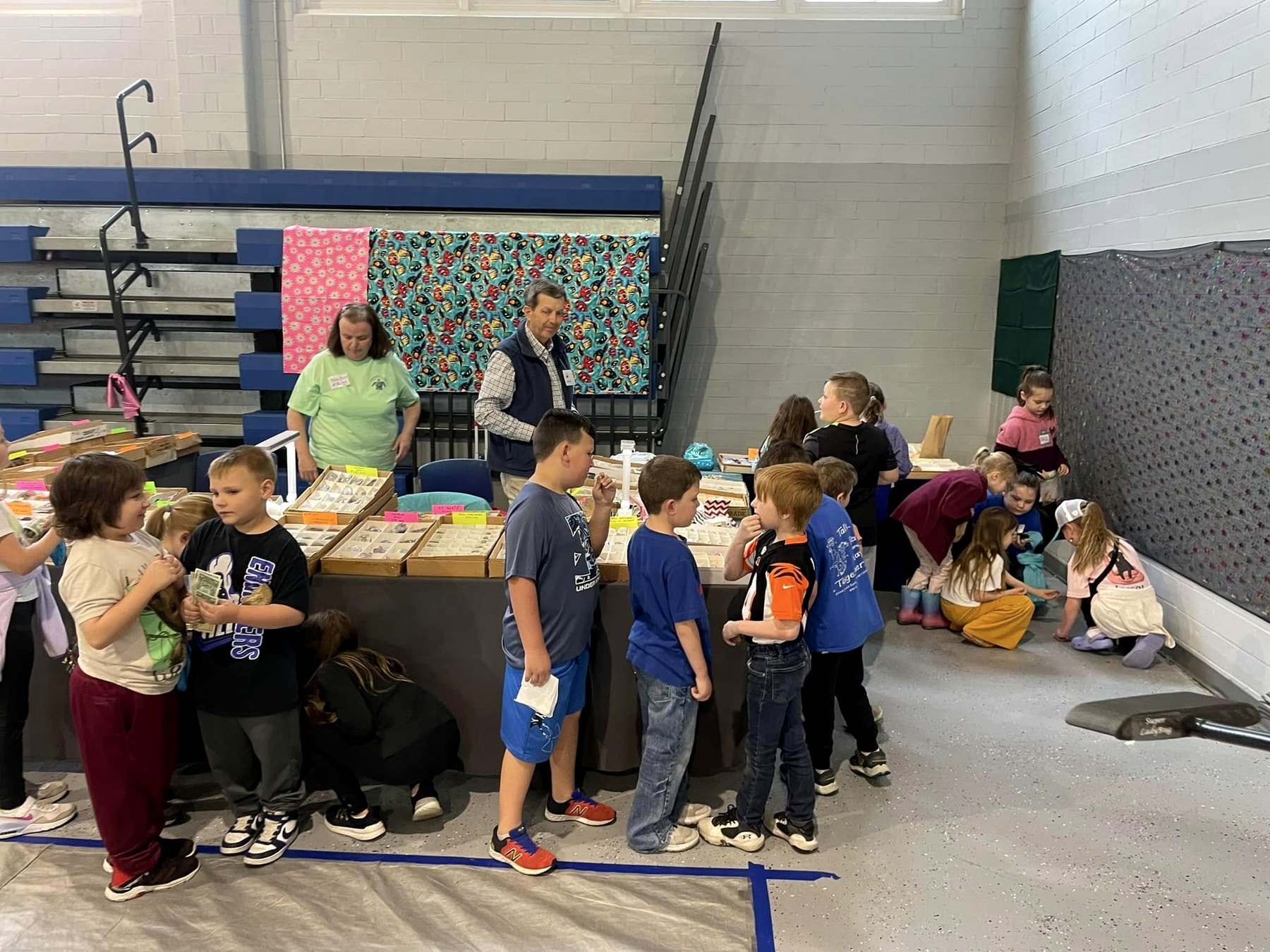 Young visitors gathered around a hands-on display during an indoor club or show activity.